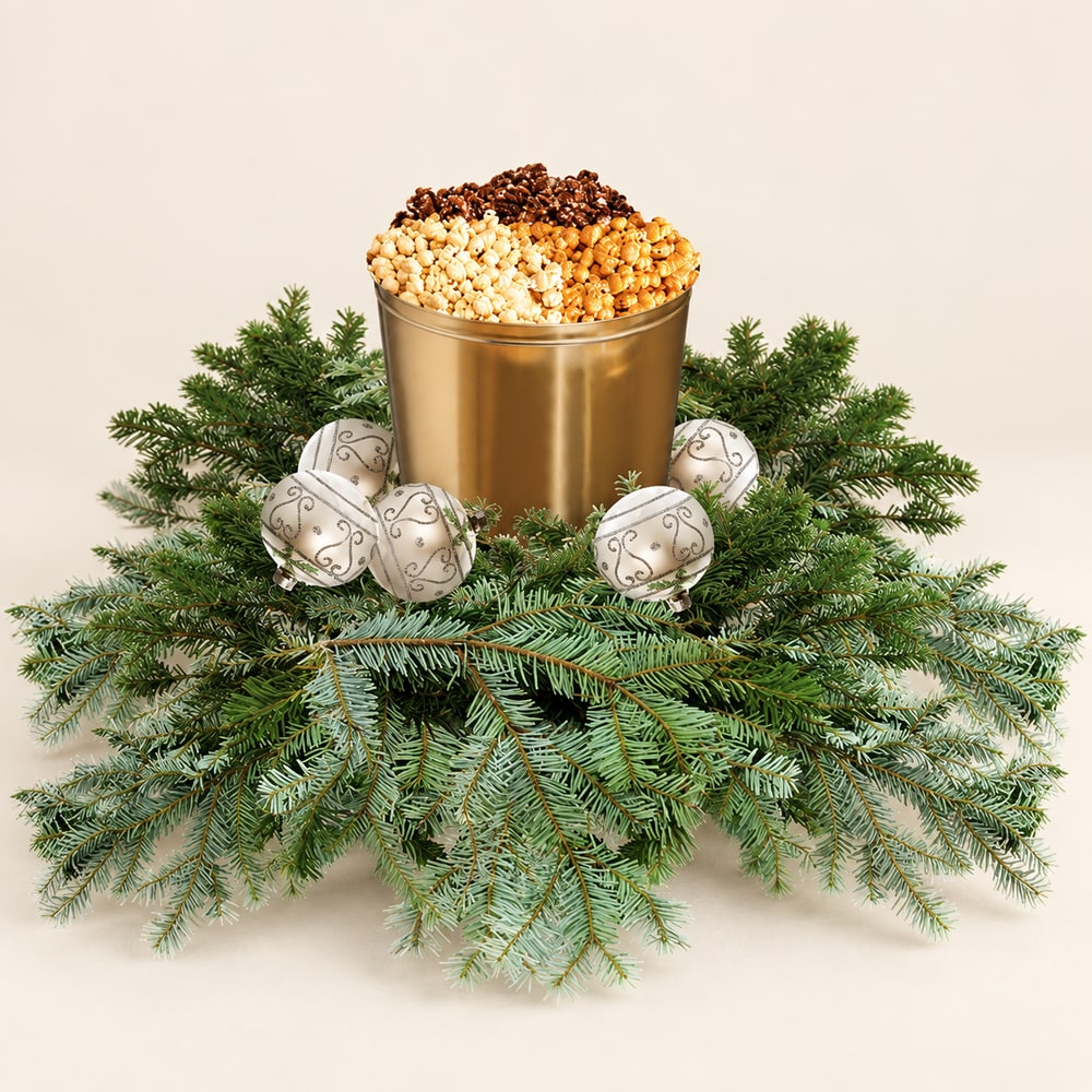 Gold popcorn tin with holiday greenery and silver ornaments